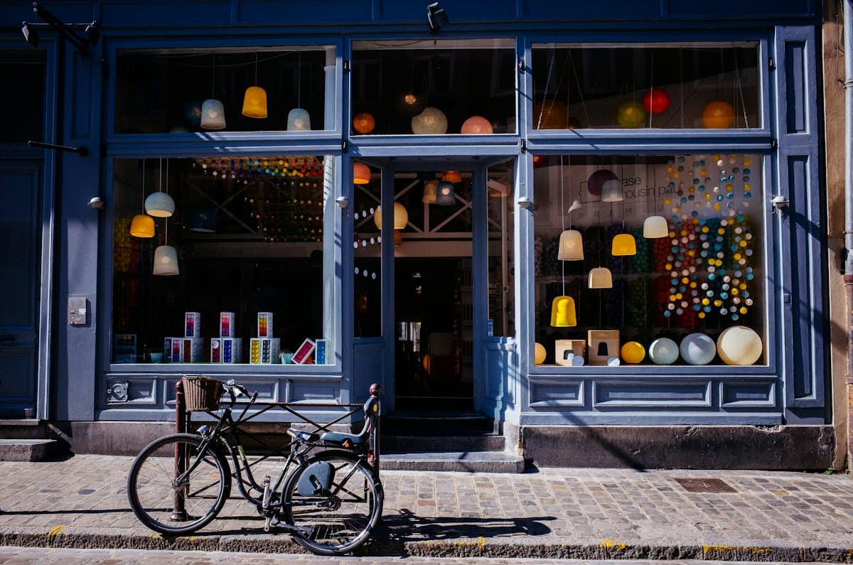 A shop window at dusk with a bicycle outside